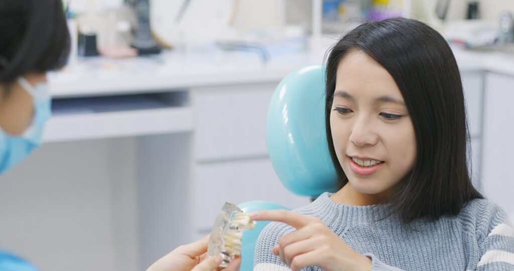 Dentist showing the implant tooth to the patient