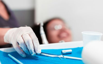 image of the hands of a professional dentist holding a dental cleaning instrument.